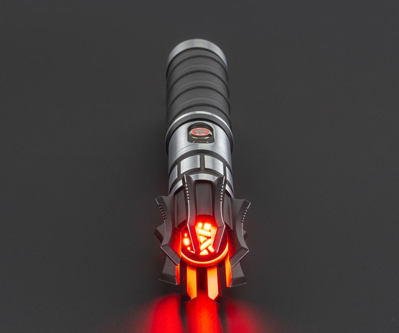 May include: A black and silver lightsaber with a red blade. The lightsaber has a detailed design with a black handle and a silver emitter.