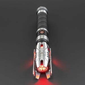May include: A black and silver lightsaber with a red blade. The lightsaber has a detailed design with a textured grip and a silver emitter.