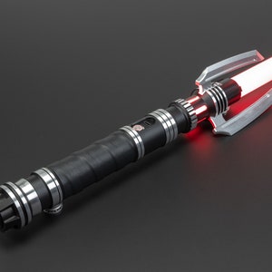 May include: A black lightsaber with a silver hilt and a red blade. The hilt has a textured grip and a silver emitter.