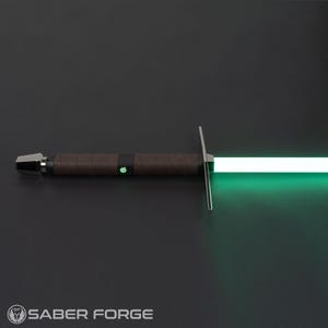 Op de afbeelding: Een lightsaber met een bruine handgreep en een groene blade. De lightsaber is aan en de blade gloeit.