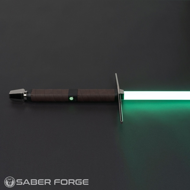 Op de afbeelding: Een lightsaber met een bruine handgreep en een groene blade. De lightsaber is aan en de blade gloeit.