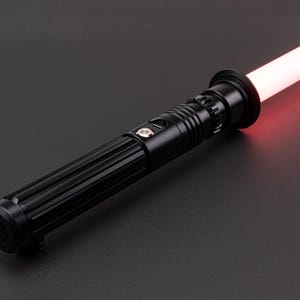 Op de afbeelding: Een zwart lightsaber met een rode blade. De lightsaber heeft een getextureerde handgreep en een zilveren knop.