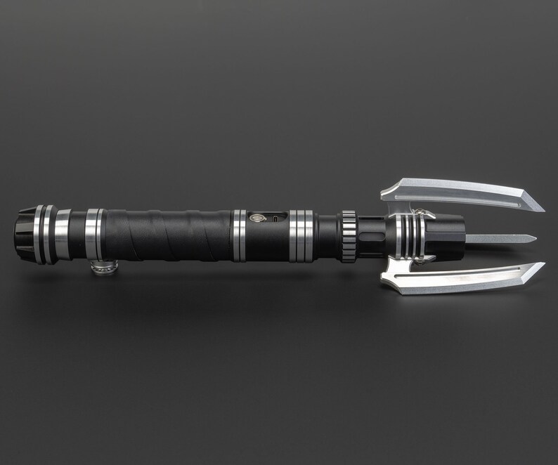 May include: A black lightsaber with silver accents and a triple-pronged blade. The lightsaber has a textured grip and a silver button on the side.