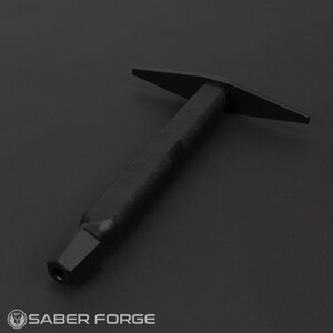 May include: A black metal tool with a long handle and a flat, T-shaped head. The tool is designed for use with a lightsaber.