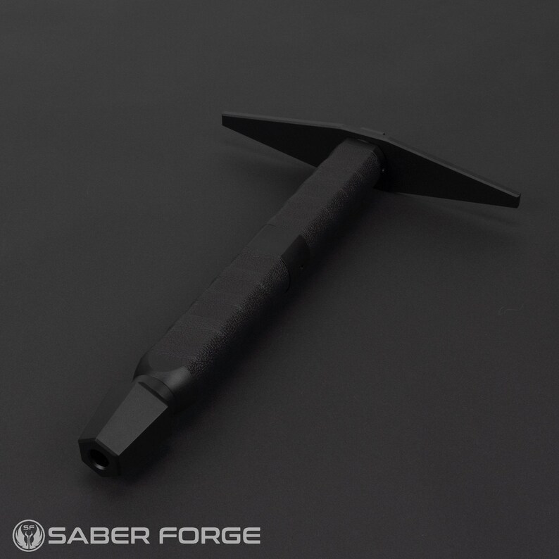 May include: A black metal tool with a long handle and a flat, T-shaped head. The tool is designed for use with a lightsaber.