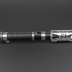 May include: A black lightsaber with a silver and black hilt. The hilt has a textured grip and a silver emitter.