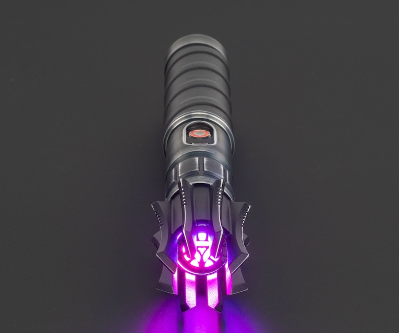K&ouml;nnte beinhalten: Ein schwarzes Lichtschwert mit einer violetten Klinge. Das Lichtschwert hat ein detailliertes Design mit einem schwarzen Griff und einem silbernen Emitter.