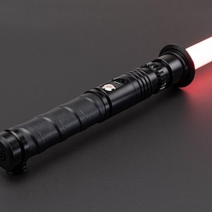 May include: A black lightsaber with a red blade. The lightsaber has a textured grip and a black emitter.