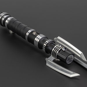 May include: A black and silver lightsaber with a unique, angular design. The lightsaber has a black handle with silver accents and a silver blade.
