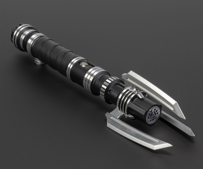 May include: A black and silver lightsaber with a unique, angular design. The lightsaber has a black handle with silver accents and a silver blade.