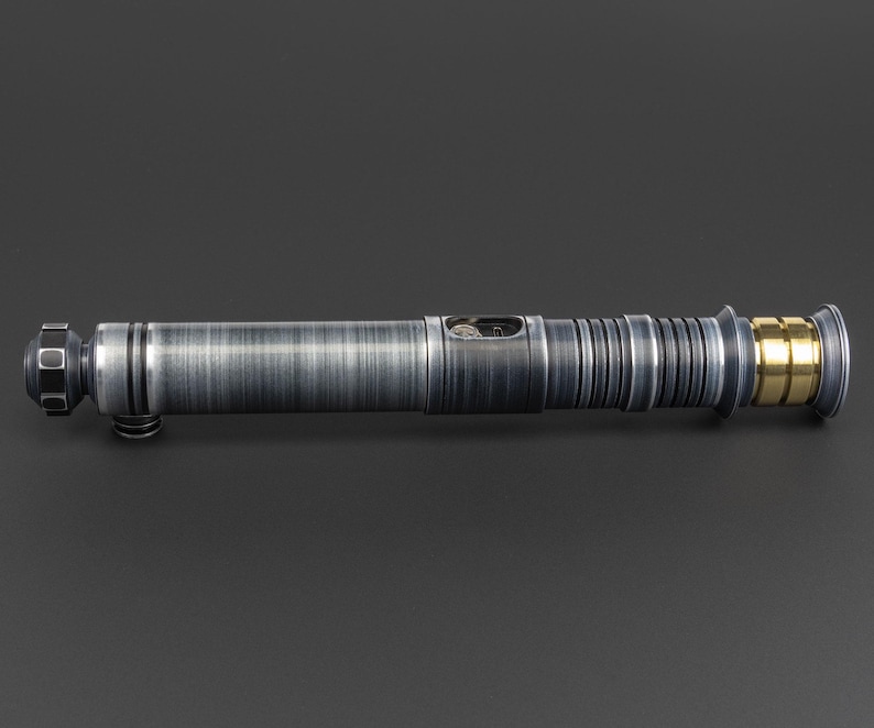 Puede incluir: Un sable de luz plateado con un acento dorado en el mango.