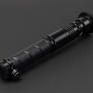 May include: A black lightsaber prop with a textured grip and a black metal hilt.
