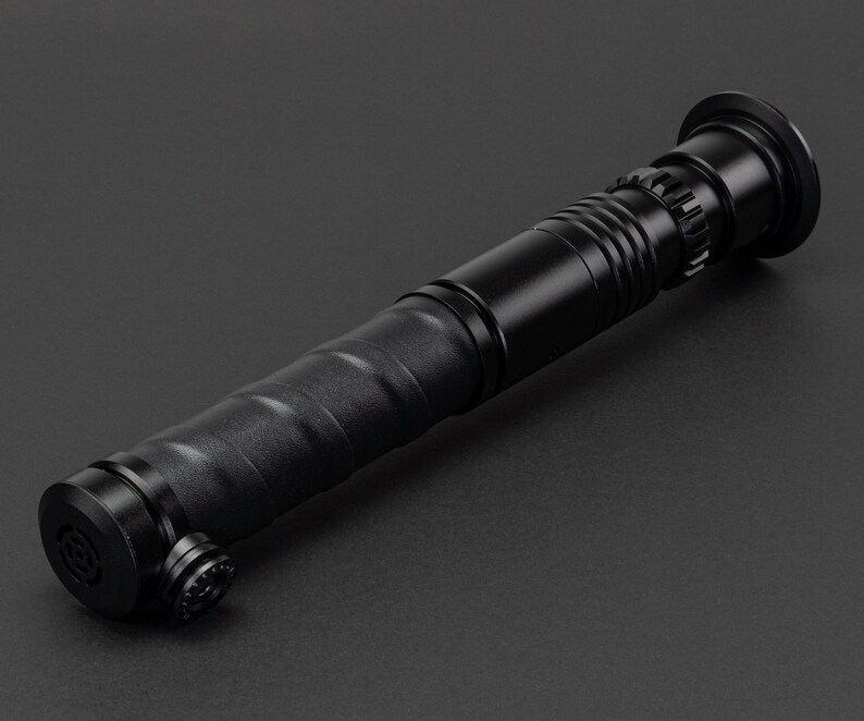 May include: A black lightsaber prop with a textured grip and a black metal hilt.