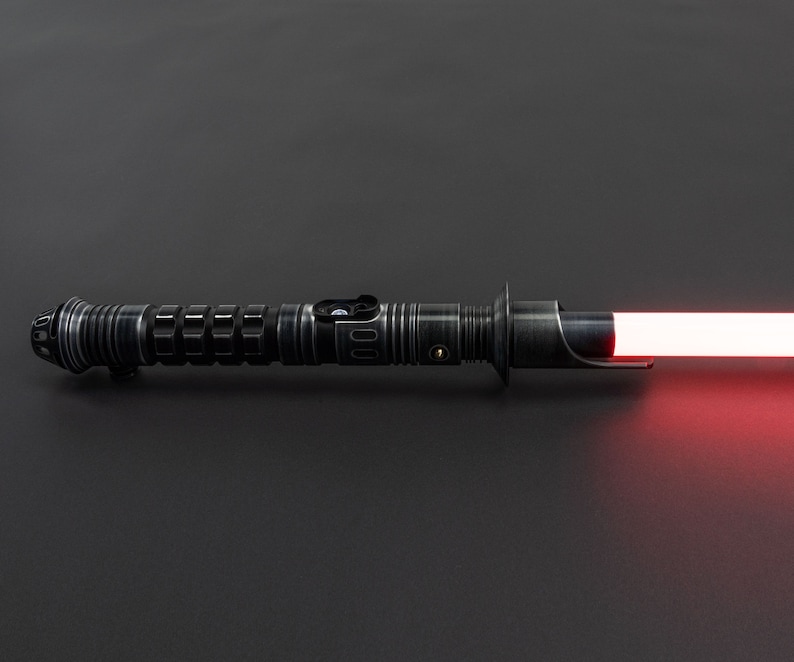 K&ouml;nnte beinhalten: Ein schwarzes Lichtschwert mit einer roten Klinge. Das Lichtschwert hat einen strukturierten Griff und einen silbernen Akzent.