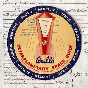 May include: A vintage Interplanetary Space Guide by Walls. The circular guide features a red and cream rocket design with planet names around the edge. Includes facts about Mercury, Pluto, Venus, Earth, Moon, Mars, Jupiter, Saturn, Uranus, and Neptune.