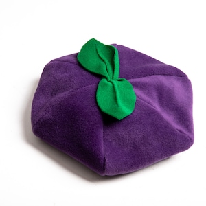 May include: A purple fleece beret with a green felt leaf design on top.