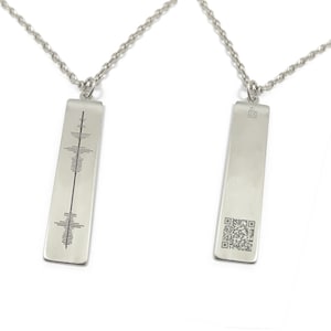 May include: Two silver necklaces with rectangular pendants. One pendant has a sound wave design, the other has a QR code.