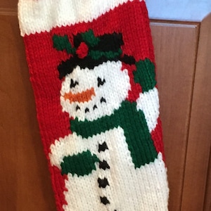 Hand knitted Christmas Stocking snowman with green scarf red back ground