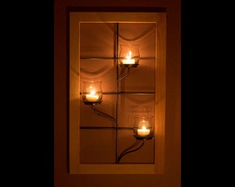Window frame wall sconce with vase style votive holder.