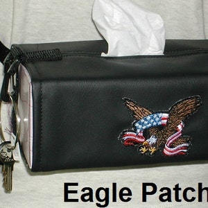 May include: Black leather tissue box holder with a shoulder strap and a key ring. The holder has an embroidered eagle with an American flag design and the words "Eagle Patch".
