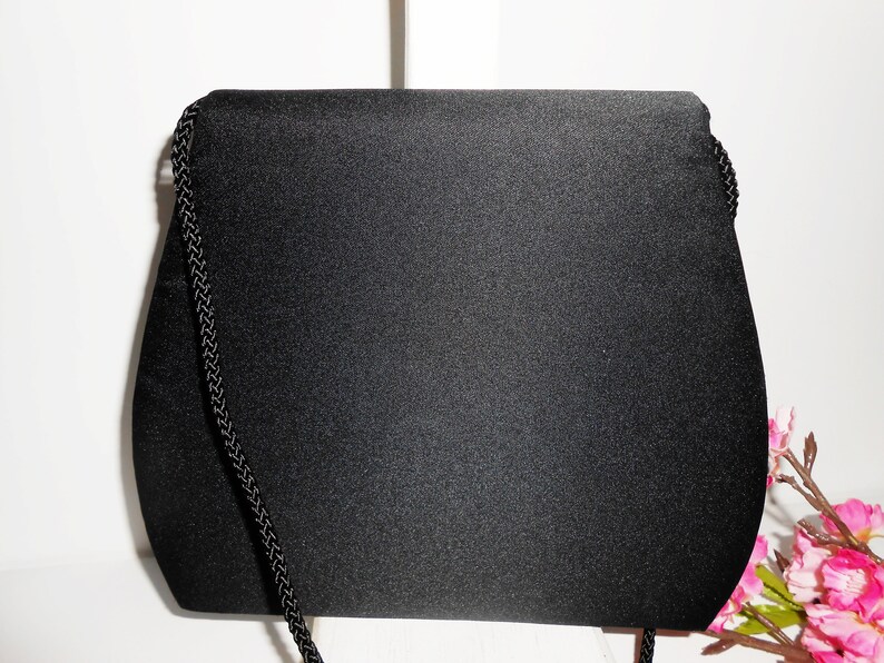 May include: A black satin evening bag with a black braided chain strap.