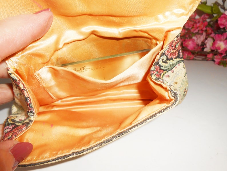May include: A vintage tapestry fabric clutch purse with a satin lining and a clear plastic pocket. The pocket has the text "Bellissima" printed on it.