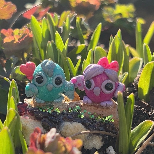 Garnet desk buddies couple of pink and blue owls sitting on a tree trunk holding a heart balloon