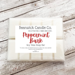 May include: A white soy wax snap bar with a label that reads "Beanwick Candle Co. Spice Up Your Space, It Makes More Scents, Peppermint Bark Soy Wax Snap Bar". To enjoy: snap off desired amount and place into a wax warmer. Store at room temperature. beanwickco.com.
