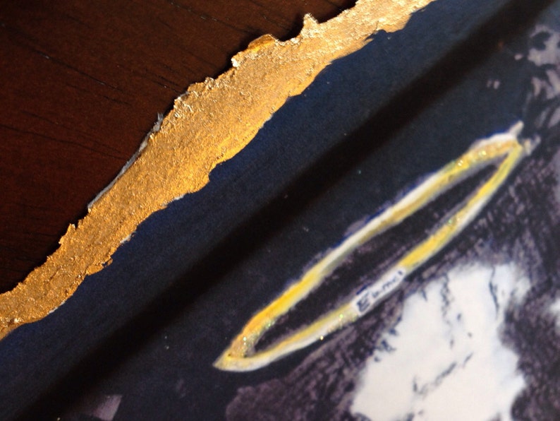 May include: A close-up of a painting with a gold border. The painting depicts a person with a halo above their head. The halo is made of gold and has a sparkly texture.