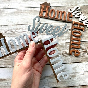 Holding one Home Sweet Home door corner decor with another in the background.