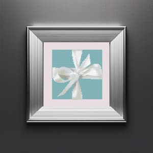 May include: A silver picture frame with a light blue background and a white bow on top. The bow is tied in a knot and the ends of the ribbon are flowing down the sides of the frame.