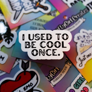 May include: A collection of colorful stickers with various designs and text. The stickers include phrases like "I Used To Be Cool Once", "Live Laugh Larp", "Good Girl Read", and "Still Emo".
