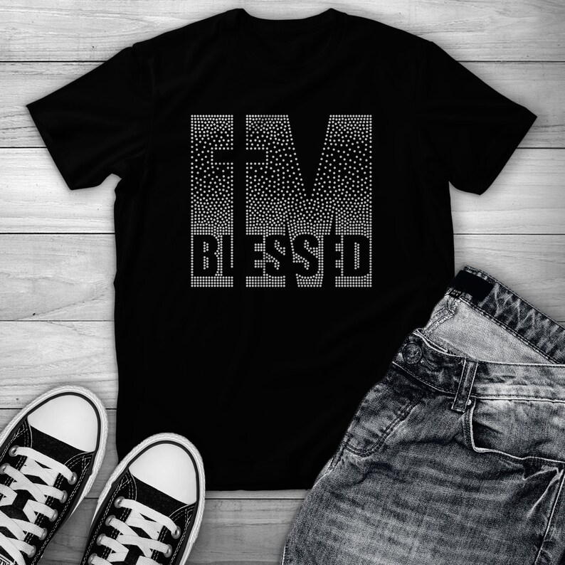 Puede incluir: Camiseta negra con las palabras "I'M BLESSED" en pedrer&iacute;a blanca.