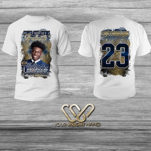 May include: White t-shirt with a blue and gold design featuring a graduate's photo, name, and school. The back of the shirt has a blue number 23 on a gold background.