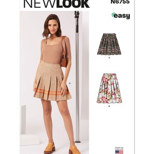 May include: A woman wearing a tan top and a pleated skirt with orange stripes. The image also shows two skirt patterns, one floral and one with a dark floral pattern. The brand name "NEWLOOK" is visible.