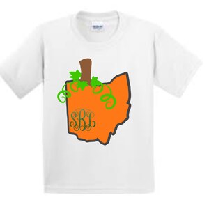 Puede incluir: Camiseta blanca con un contorno naranja en forma de calabaza del estado de Ohio. La calabaza tiene un tallo y hojas verdes y las letras "SRL" en el centro.