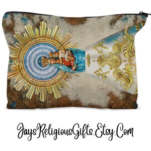 May include: A zippered pouch featuring a religious image of a woman and child within a golden sunburst design. The pouch has a textured background with a blue and gold decorative element. The text "JaysReligiousGifts.Etsy.Com" is at the bottom.
