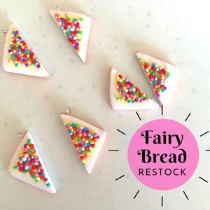 May include: Six miniature, triangular fairy bread charms with colourful sprinkles on a white and yellow base. Each charm has a silver-coloured loop at the top. The image also includes a pink circle with the text "Fairy Bread RESTOCK".