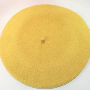 May include: A yellow beret made of soft, fuzzy material.