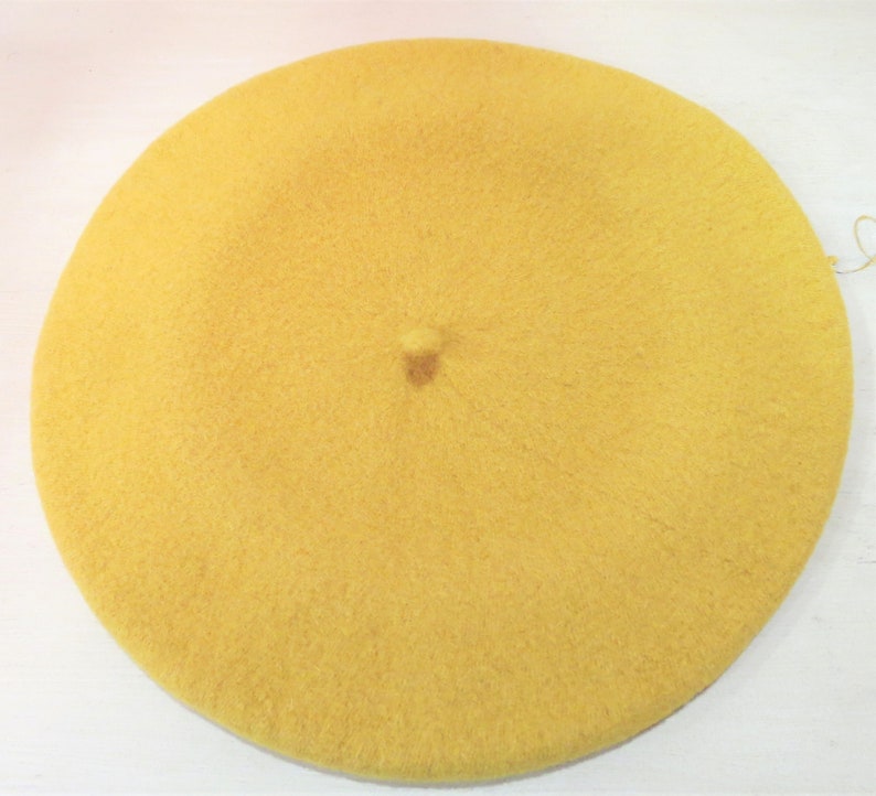 May include: A yellow beret made of soft, fuzzy material.