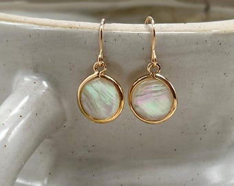 Brincos pequenos e leves de madrepérola, com cores iridescentes, em ouro 14k ou prata de lei.