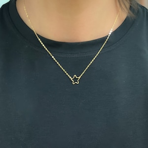 May include: A delicate gold chain necklace with a simple star pendant.