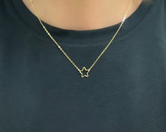 May include: A delicate gold chain necklace with a simple star pendant.