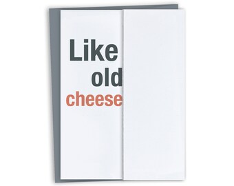 May include: A white card with gray borders and the text "Like old cheese" in black and orange.