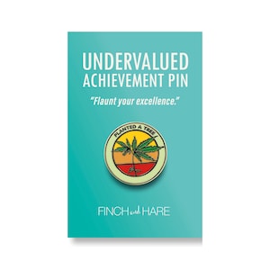 May include: A green, yellow, and red enamel pin with a green marijuana leaf plant growing out of the ground. The pin is round and has the text "Planted a Tree" around the edge. The pin is on a turquoise background with the text "Undervalued Achievement Pin" and "Flaunt your excellence." above the pin and "FINCH and HARE" below the pin.