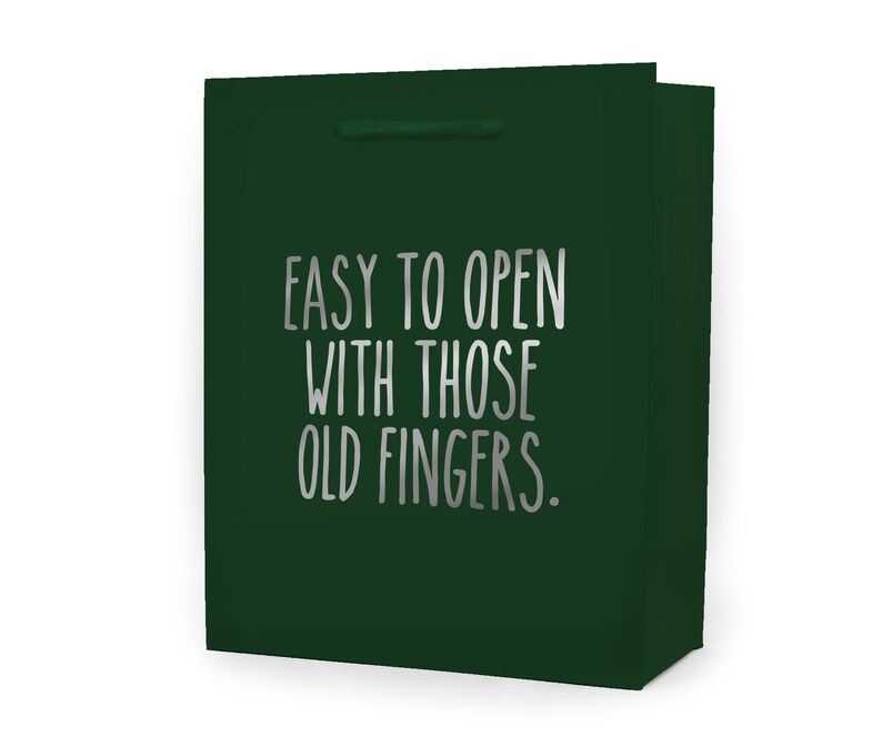 May include: A dark green gift bag with a silver inscription that reads "Easy to open with those old fingers."
