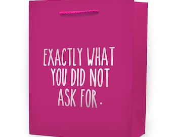 May include: A bright pink gift bag with a matching pink rope handle. The bag features the text "EXACTLY WHAT YOU DID NOT ASK FOR" in a silver, sans-serif font. The bag is rectangular and stands upright.