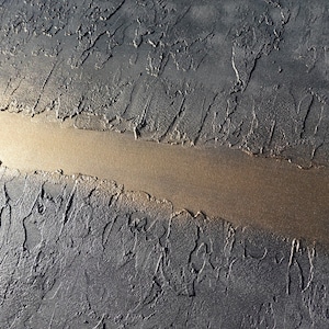 a close-up view of a textured surface with a long, narrow line running through it, creating a sense of depth and movement.