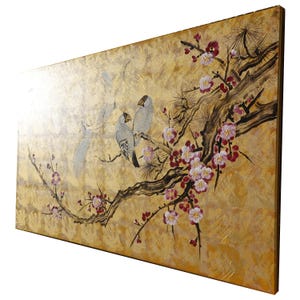 A painting of two birds perched on a branch with pink and white flowers, set against a golden background.