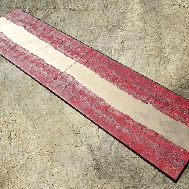 a red and white striped object, possibly a sign or a piece of art, placed on a textured surface.